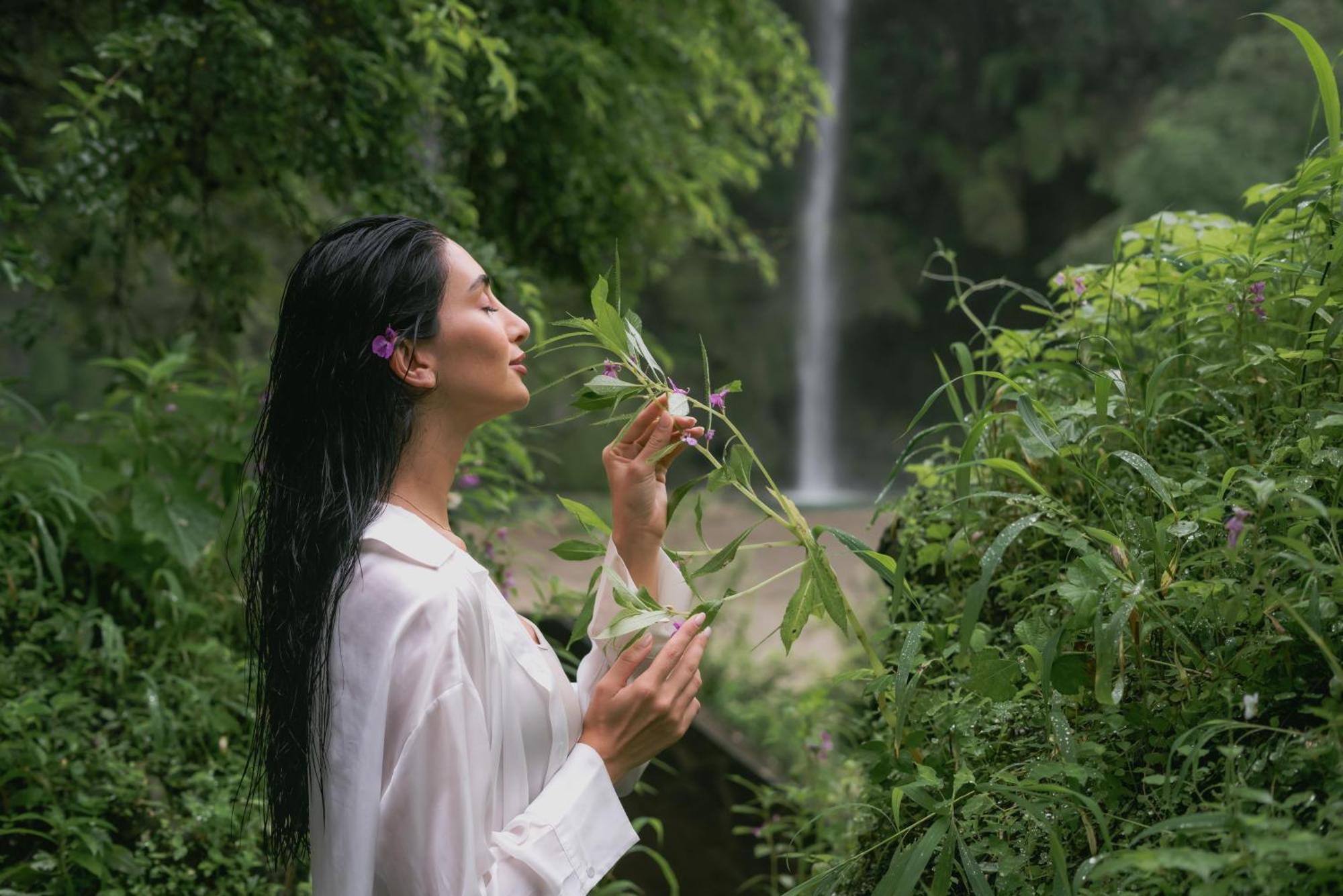 Salalah Rotana Resort Esterno foto A woman smelling flowers